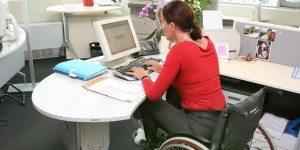 Woman in wheelchair working at a desk