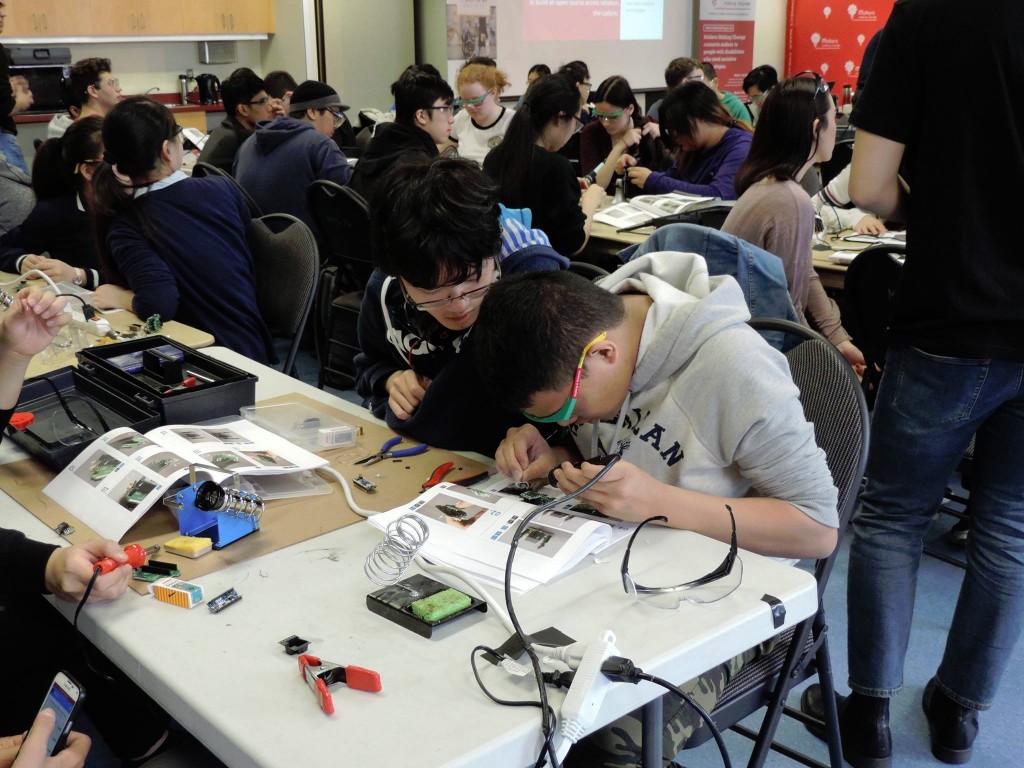 Students working diligently on the soldering process at the beginning of the day.