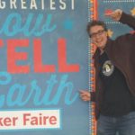 Chad Leaman, Director of Innovation, pointing at a Maker Faire sign