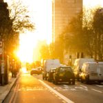 cars driving in a city with morning sun