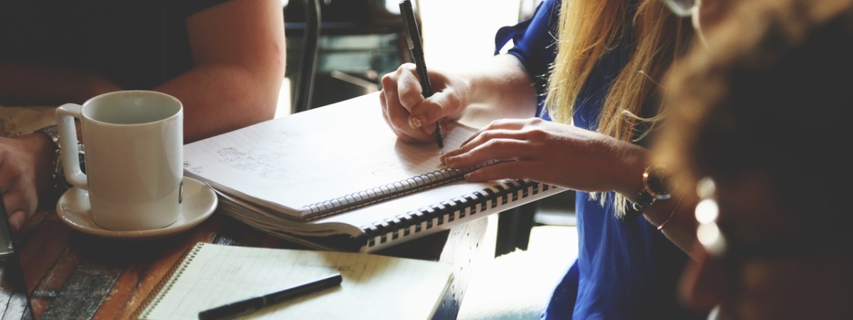 a woman making notes at a meeting