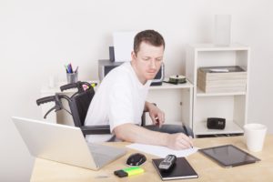 Man in wheelchair working at desk