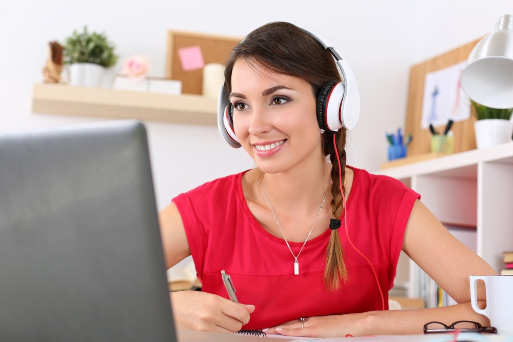 Woman with headphones at a computer