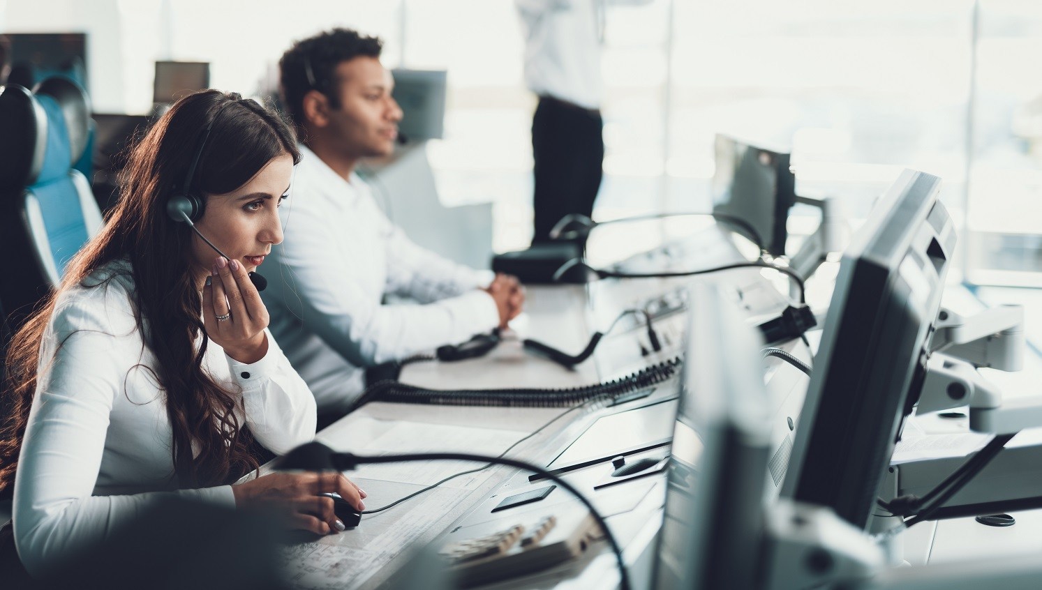 Two persons with headsets at a computer