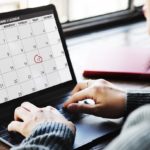 A woman using a calendar on her laptop