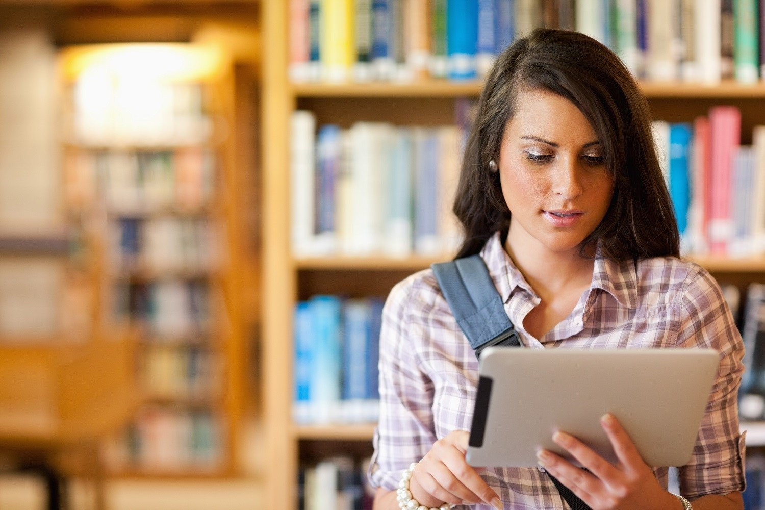 A woman using a tablet in a librray