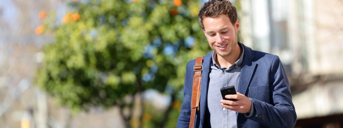 Man walking on the street looking at his phone