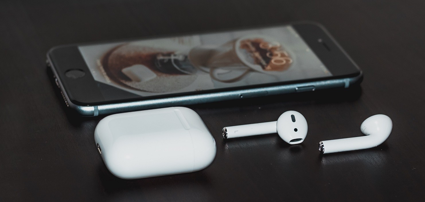 Apple AirPods with an iPhone in the background