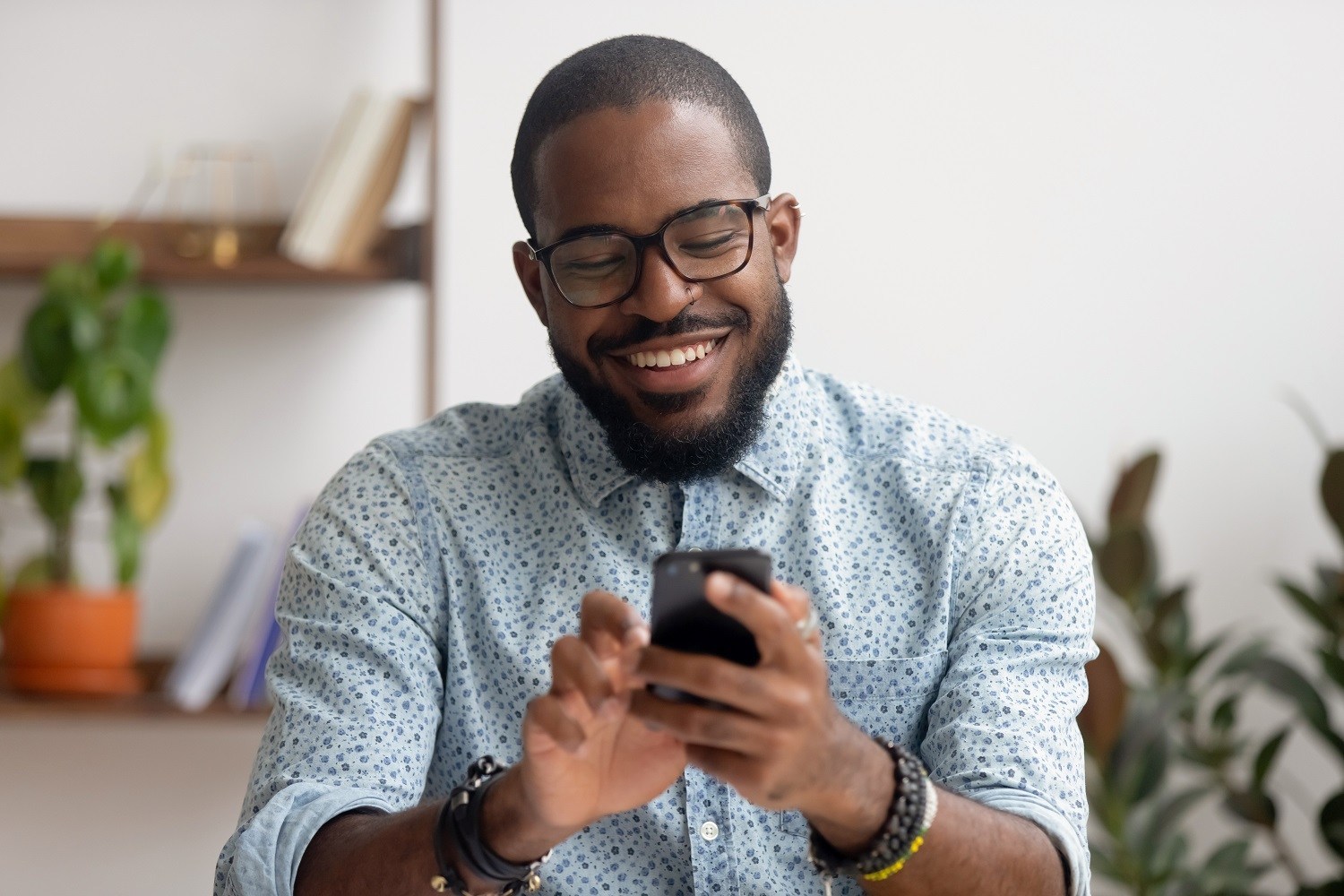 man smiling and using his smartphone