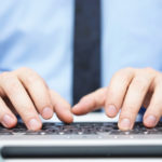 close-up of hands typing on a keyboard