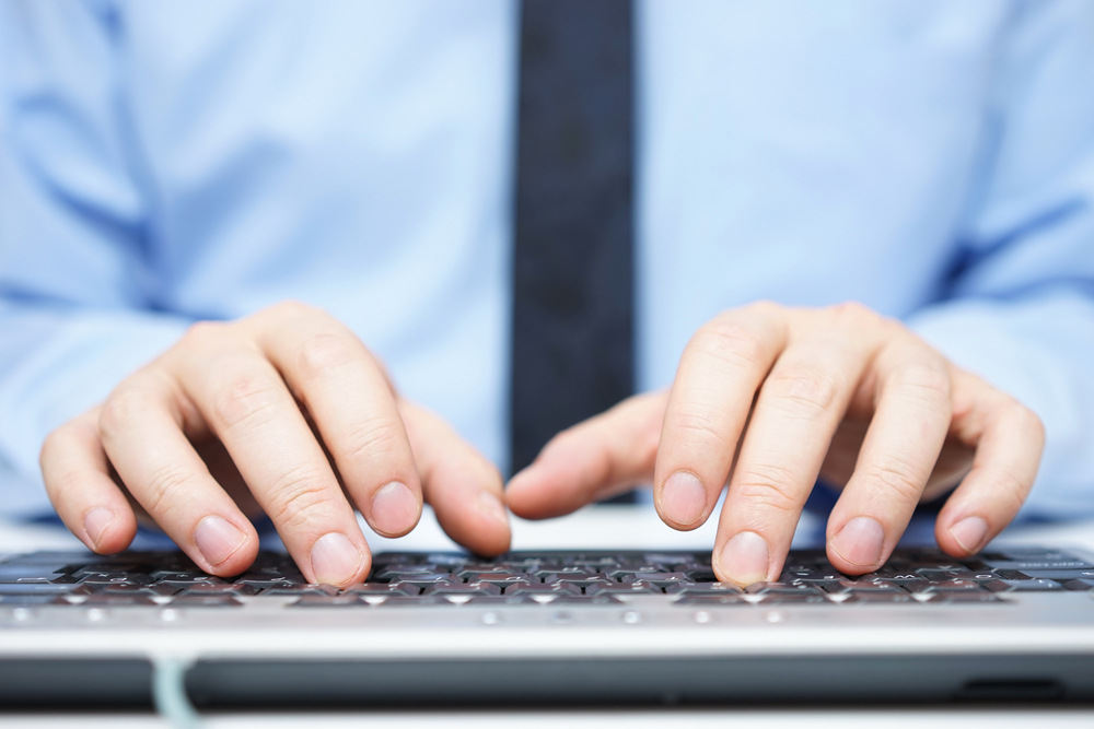 close-up of hands typing on a keyboard