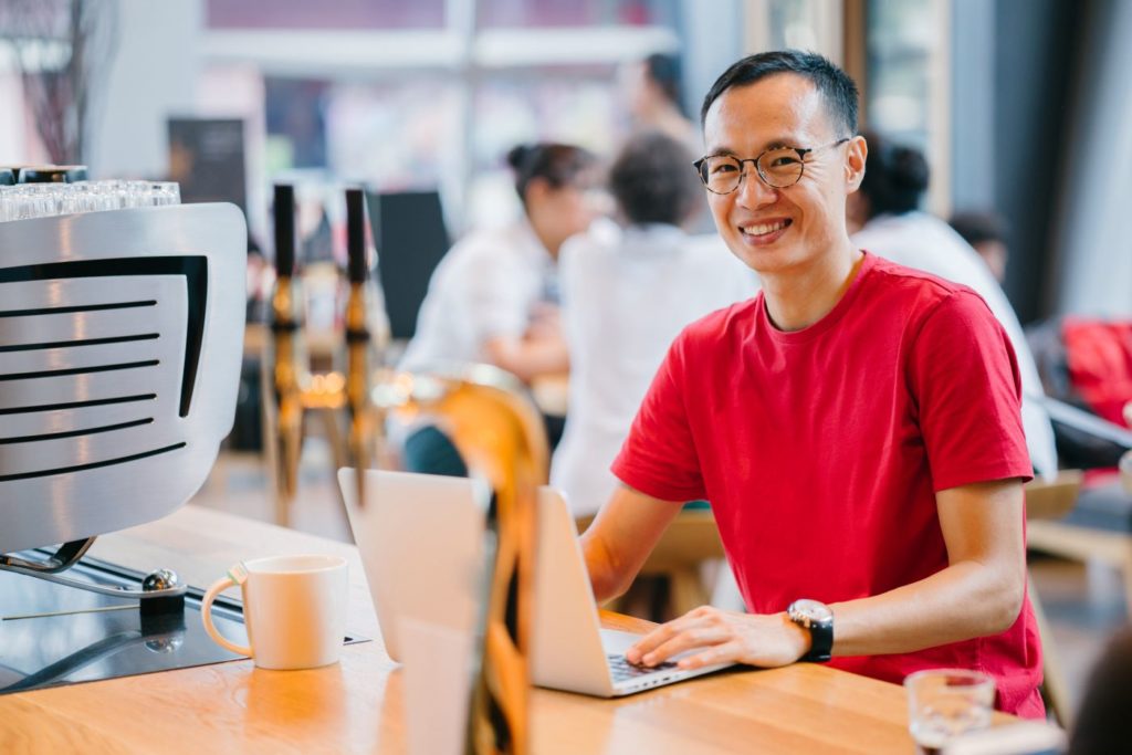 stock image of man working on a laptop at a desk