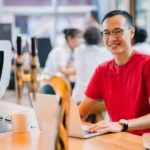 stock image of man working on a laptop at a desk