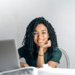 stock image of woman smiling, working at her laptop