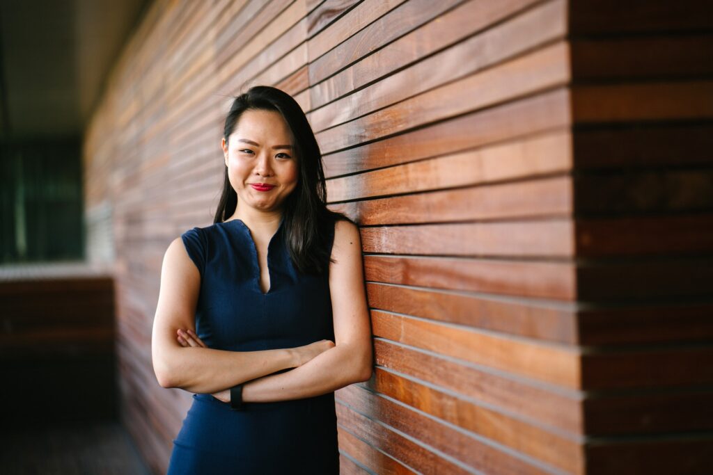 woman standing against a wall, smiling