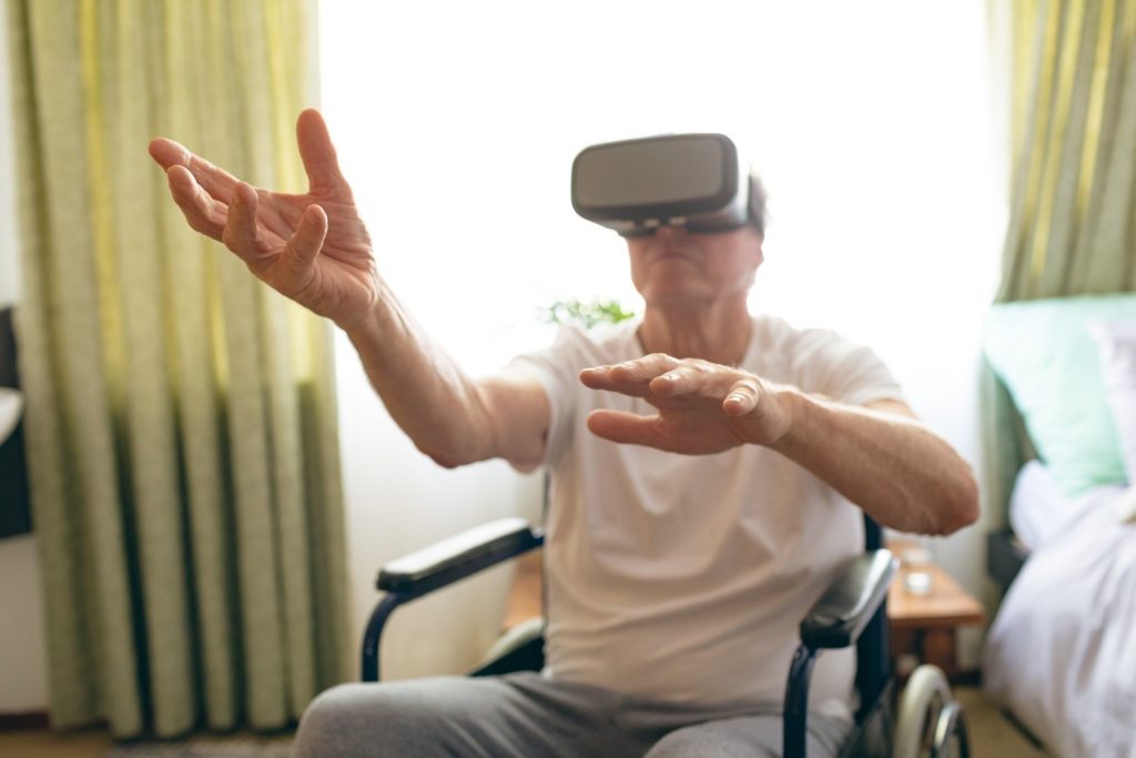 man seated in a wheelchair, using a virtual reality set