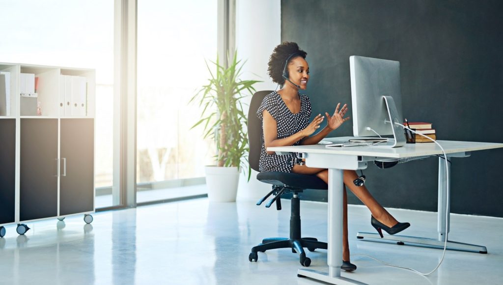 woman wearing a headset, working at a desktop computer