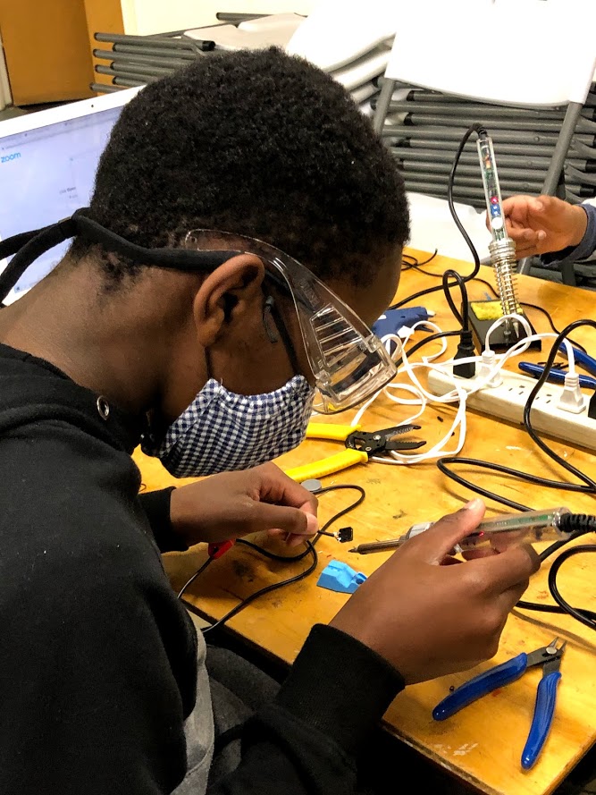 A student soldering their device together