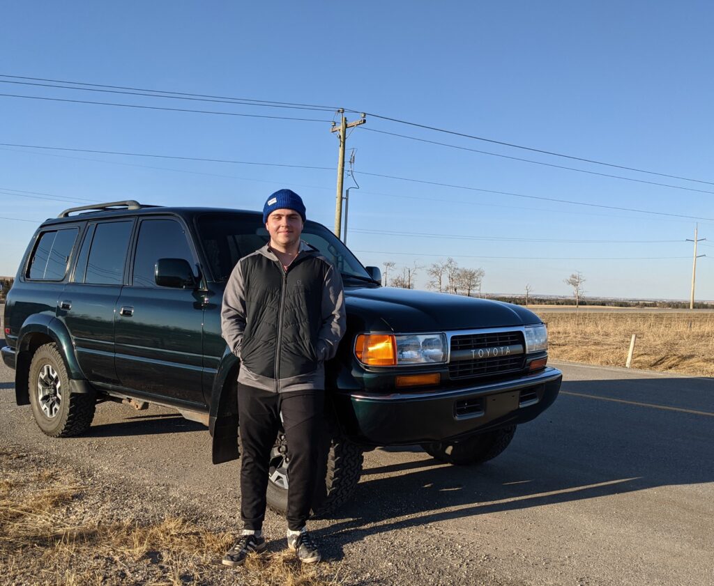 Tyler stands in front of vehicle on the side of the road