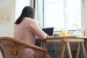 a woman working on her laptop at her home office