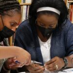 two women working together to build a switch