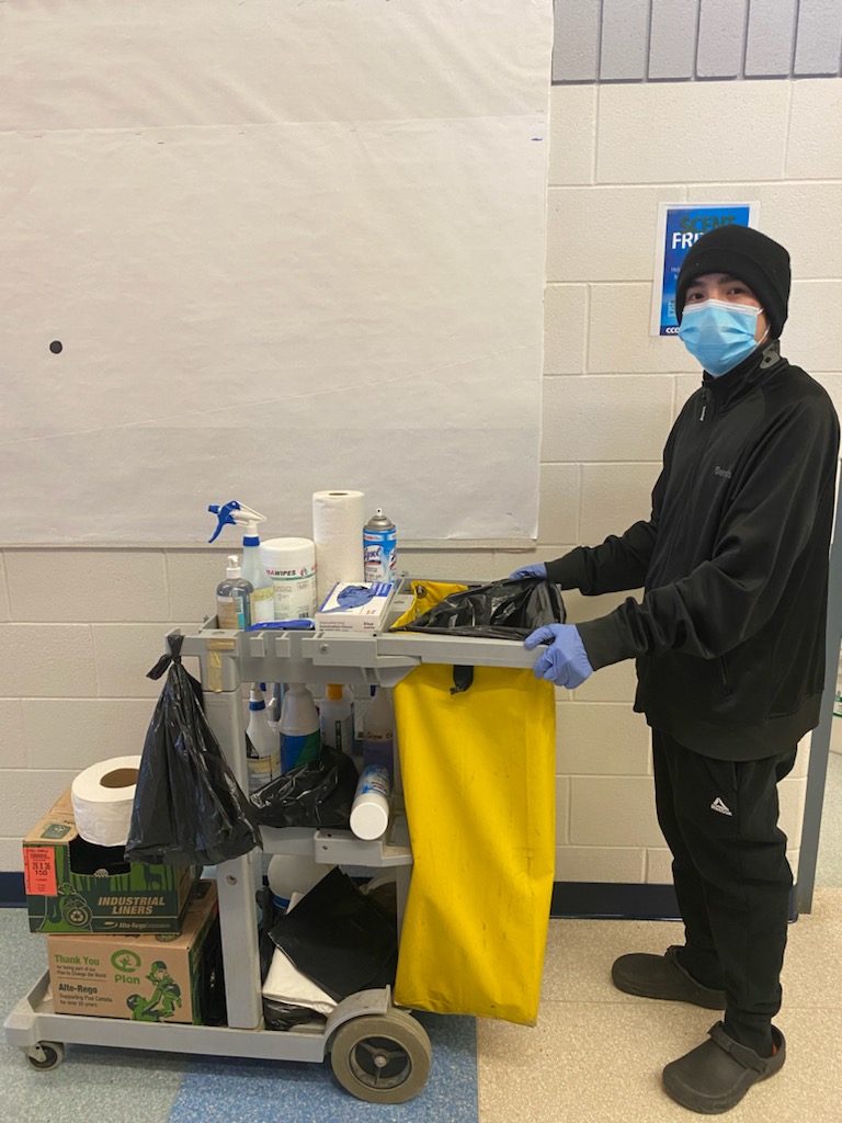 Group Employment Skills participant Jarvis moving a cleaning cart while wearing a mask