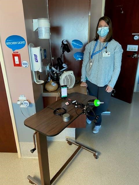 Marla Calder standing in front of a small movable table with various assistive technology