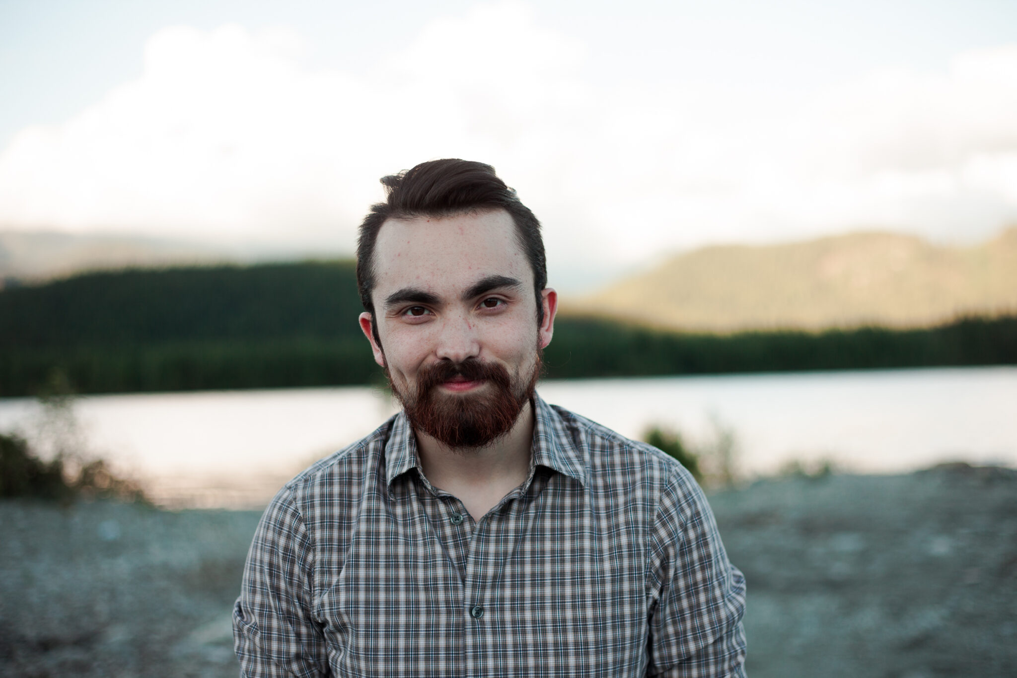 Scott smiling into the camera with a mountain and lake in the background