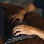 a man typing on a laptop