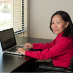 Working Together participant Sheryl in a wheelchair using a laptop