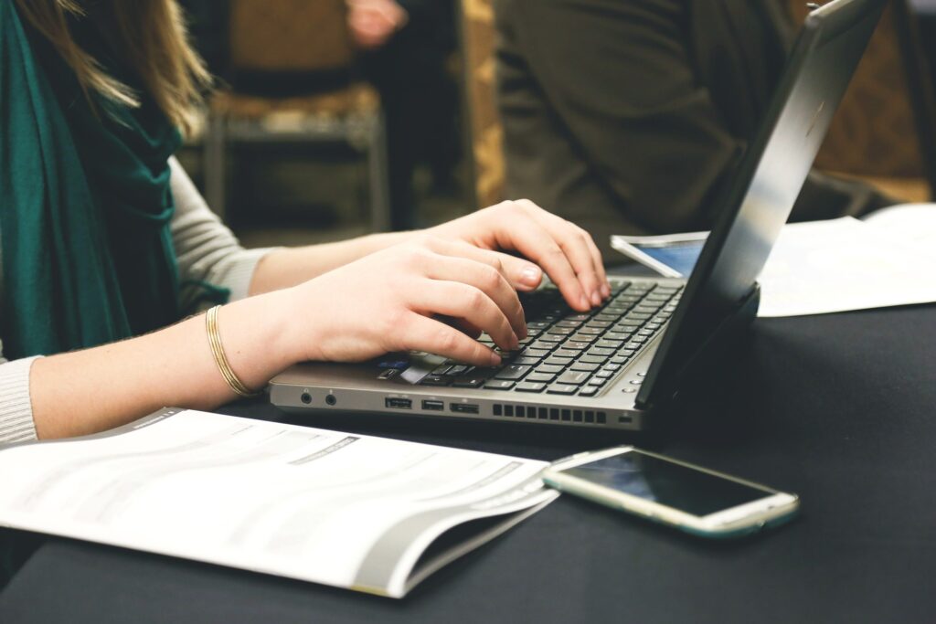 a woman types on a laptop