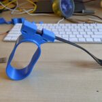 A blue 3d printed universal cuff with a fork