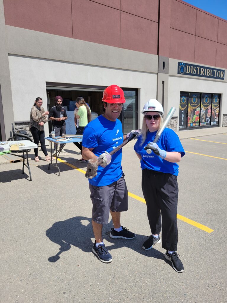 Pran and Chelsea posing with a baseball bat and a sledgehammer