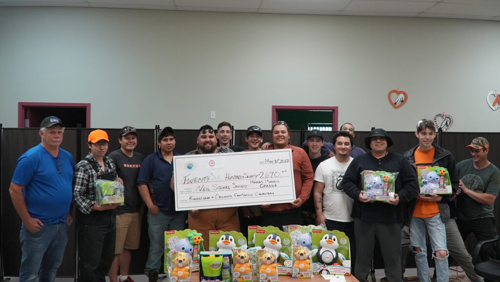 the volunteers showing off their adapted toys and a cheque to Neil Squire for $2,670