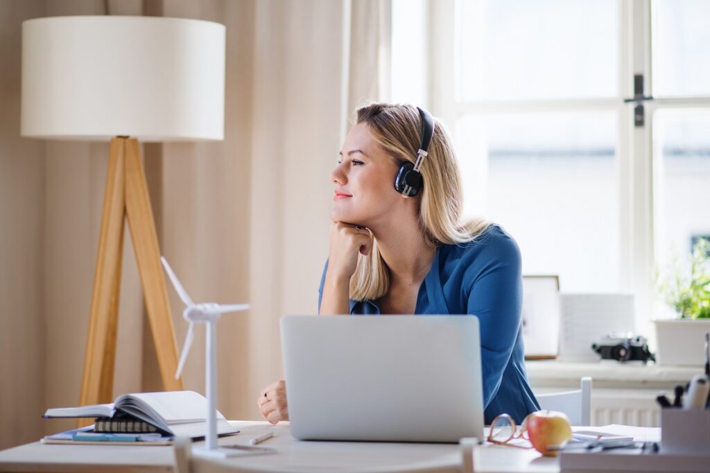 a woman wearing a headset while using a laptop