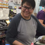 Working Together participant Christine ringing in groceries at her till at a grocery store