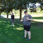 Working Together participant Wyatt standing in a park giving a thumbs up