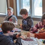 Emmett and other kids at D-Camp making devices at a table