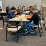 High school students work together at the North Forge Build to make devices