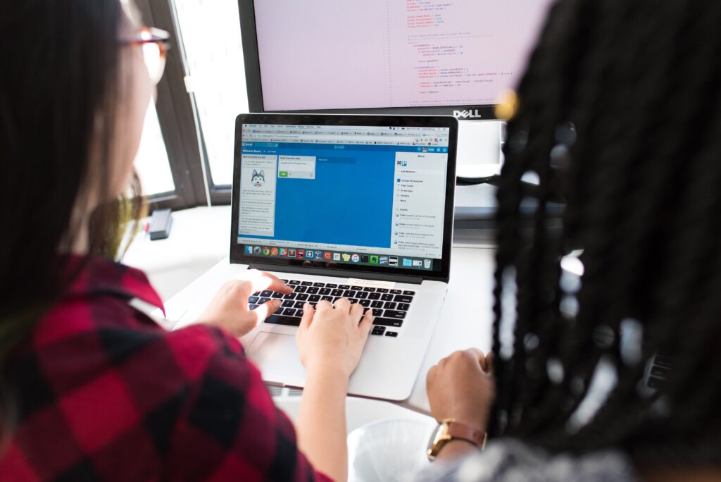 two people looking over a computer screen