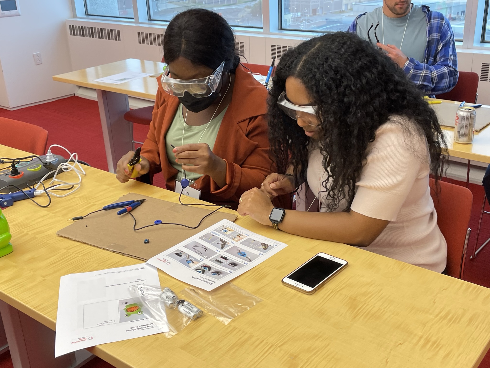 two women working together to build a device