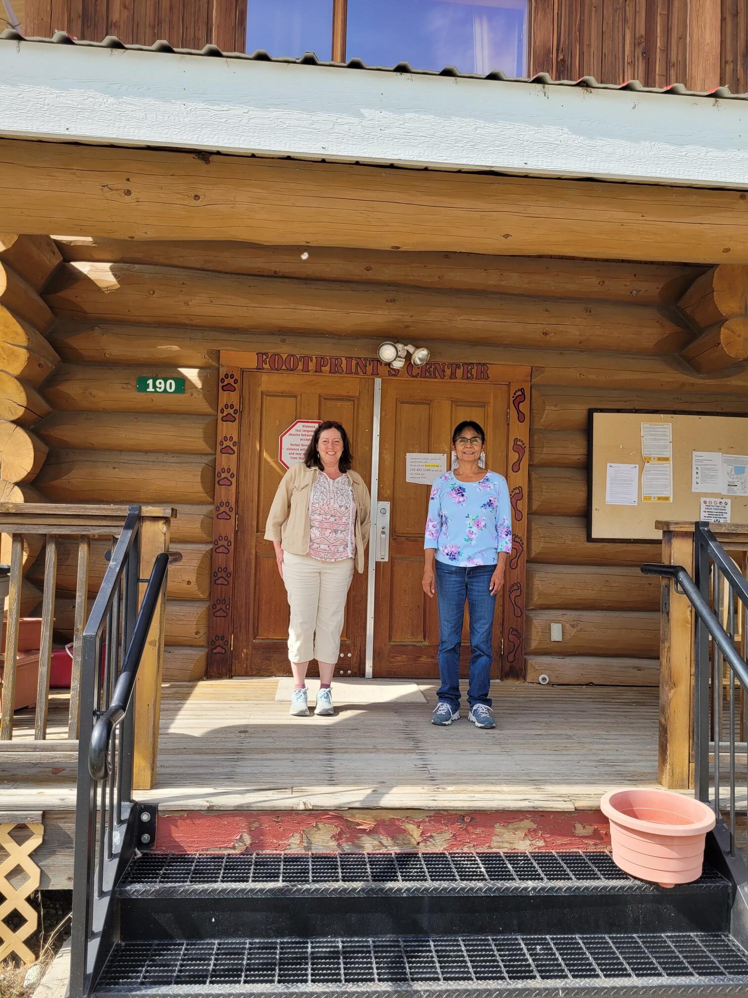 Mindy and Terry standing outside on the porch at the Footprints Centre