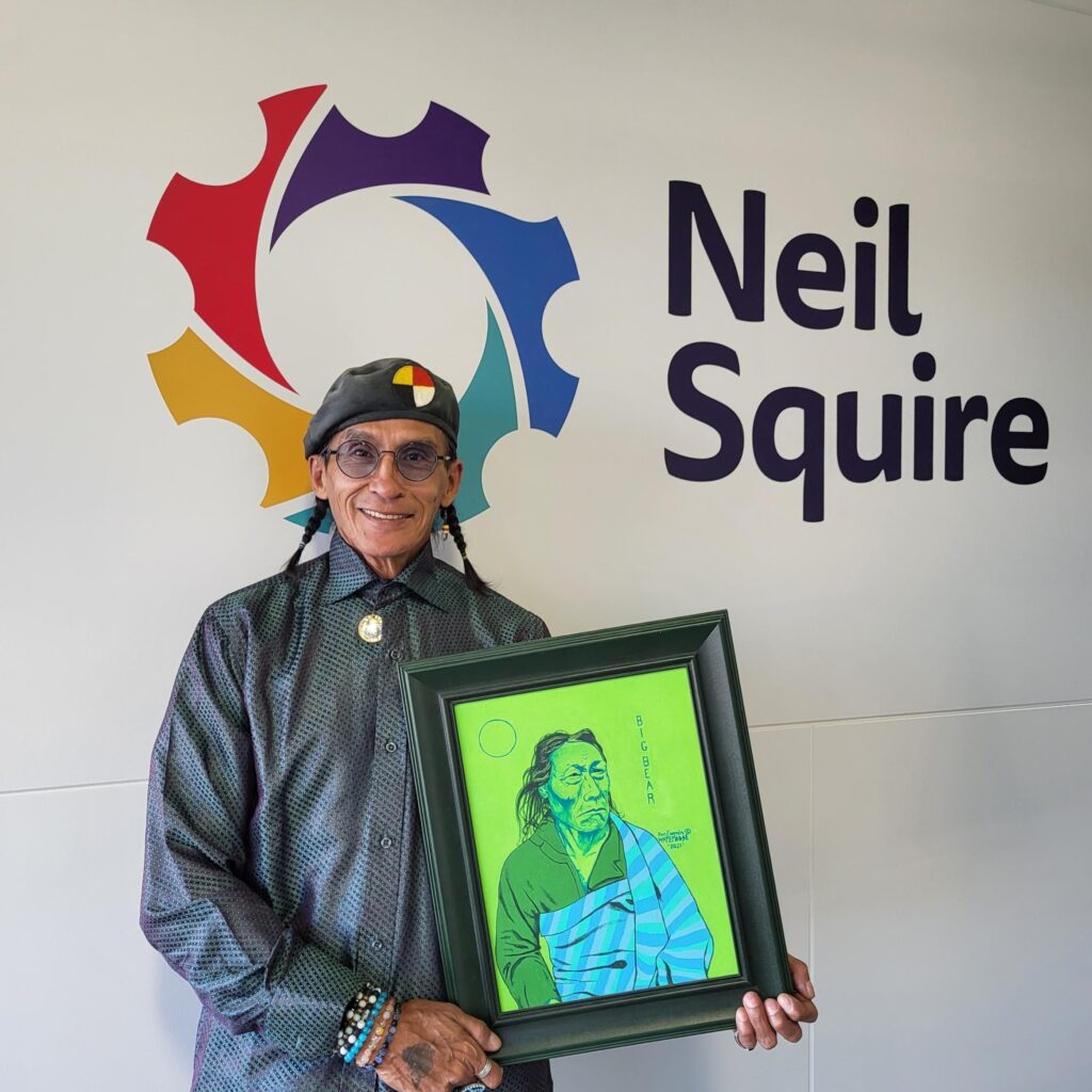 Computer Comfort participant Ron holds one of his paintings, a portrait of a man with the name, "Big Bear"