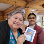 Footprints participant Patricia holding her prize, standing next to Terry, who helps run the Footprints Centre