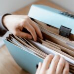 a person sorting through files in a folder