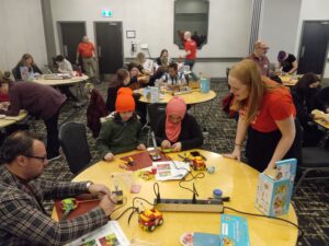 a Makers Making Change staff member helps out a family at a build event in New Brunswick