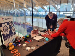 a man learns how to solder at the Neil Squire exhibit, which features devices from Makers Making Change