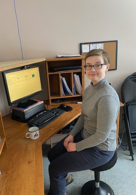 Working Together participant Emily sitting at her work desk on her wobble chair