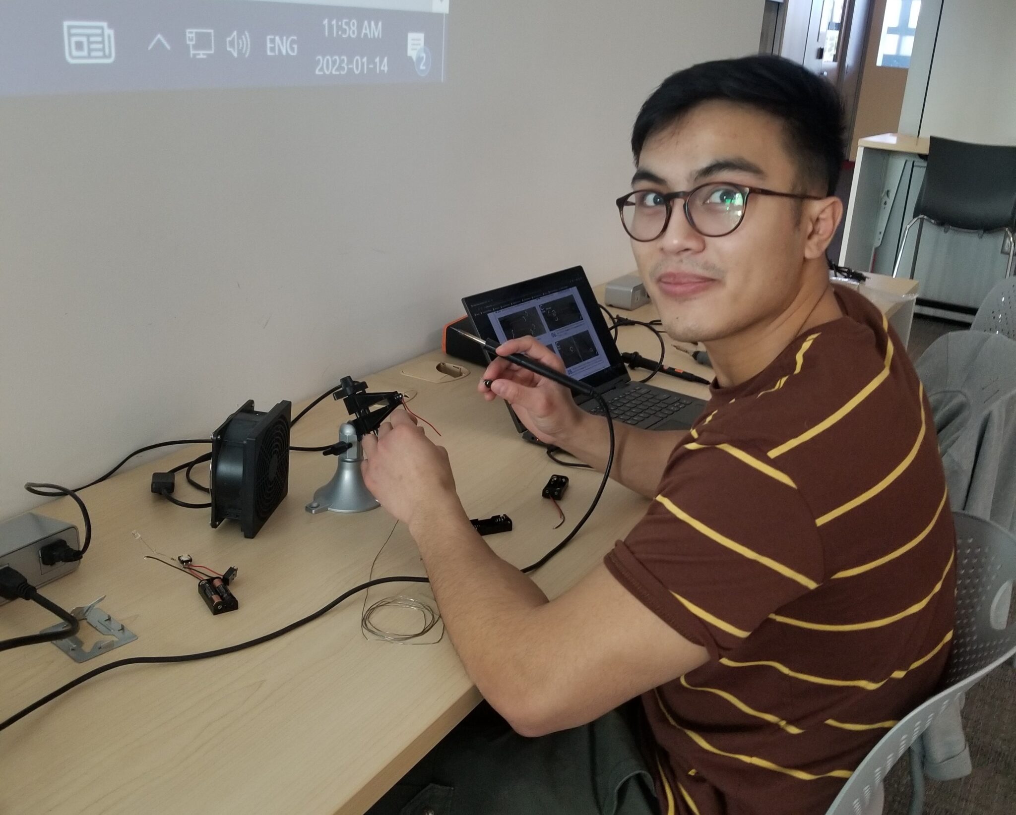 a student uses a soldering iron to work on a switch