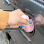 a person using a Gas Cap Opener to open a gas cap off a vehicle